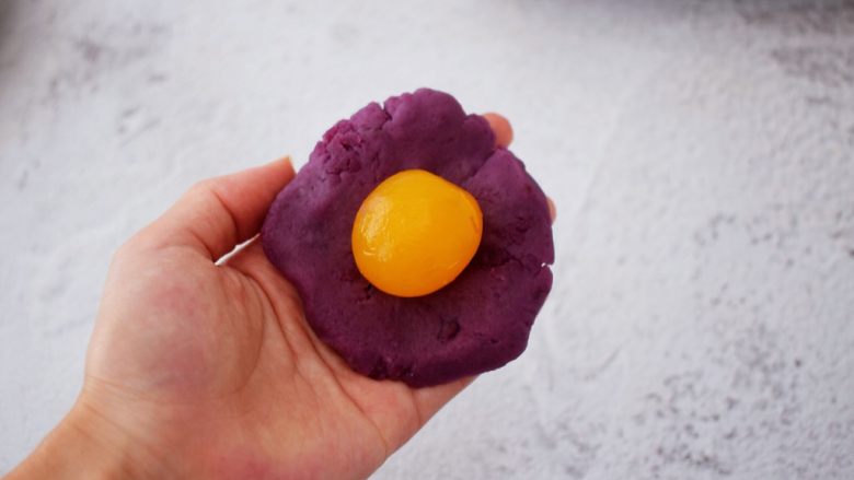 紫薯蛋黄月饼,然后紫薯按扁放入蛋黄