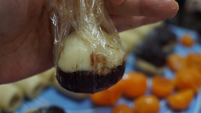 肉松麻薯蛋黄酥,然后利用保鲜膜将馅料捏紧实,滚圆