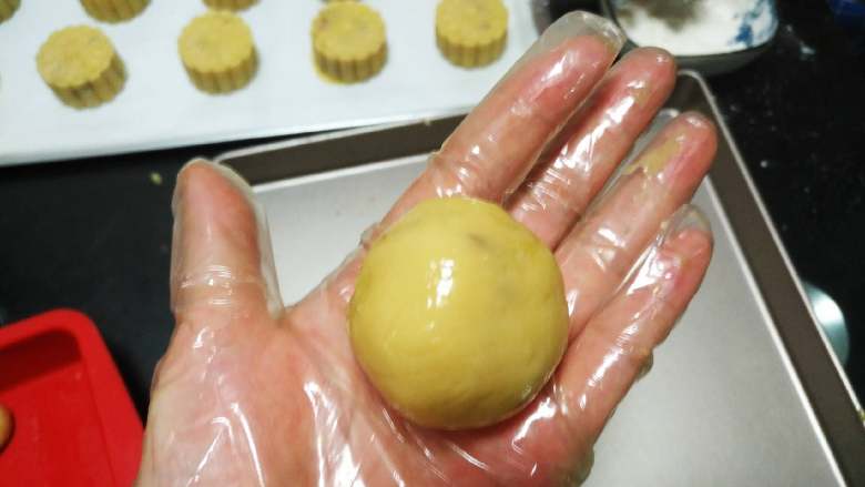椰蓉蔓越莓月饼,用手的虎口位置,把饼皮的四周向上推,边推边收口,包好,滚圆
