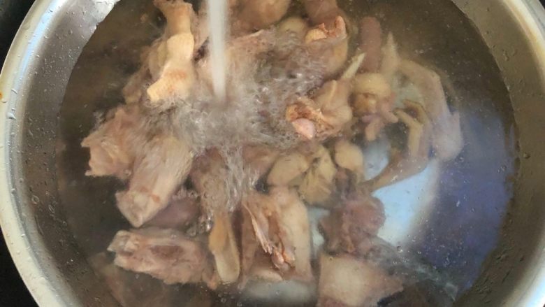 虫草花鸭汤,把鸭肉倒入大盆里,用冷水冲凉,清理干净鸭肉上的细毛
