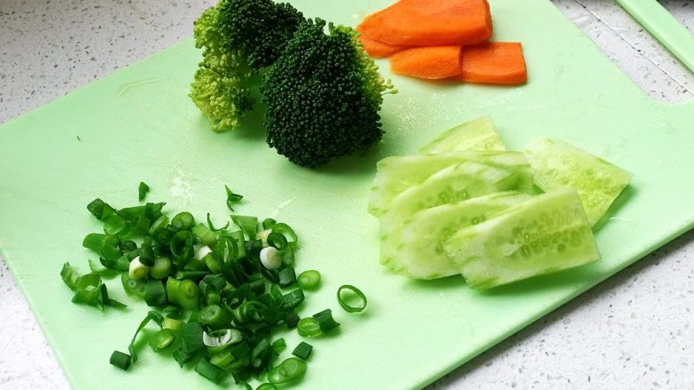 铸铁珐琅锅·红烧牛肉面,煮面前,西蓝花洗净,小葱切成葱花,黄瓜和胡萝卜切片;