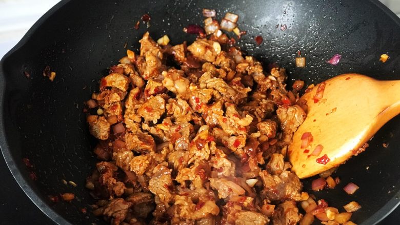 铸铁珐琅锅·红烧牛肉面,将牛腩和辅料炒匀,色泽相当诱人;