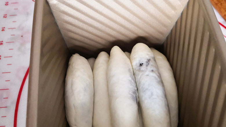 豹纹吐司,把包的面团放入吐司盒里,进行二次发酵,发至吐司盒的8分满即可,盖好盖子,烤箱预热,上下火,最下层180度,烤45分钟出炉。