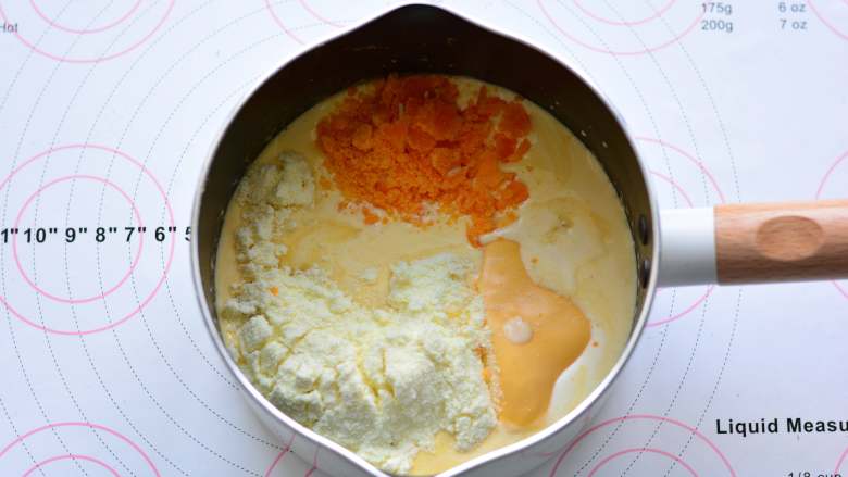 奶黄流心月饼,搅拌均匀后放入奶粉、细砂糖、芝士片、蒸熟的咸蛋黄,用手动打蛋器搅拌均匀,