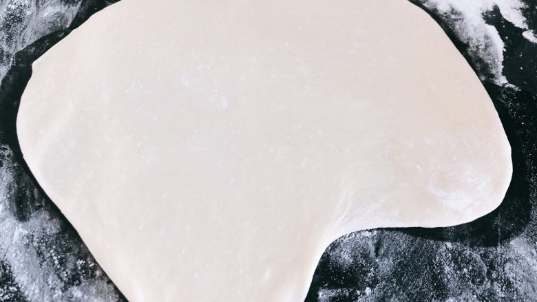 火腿鲜虾花饼塔,用擀面杖擀出一块任意形状面饼,面板需撒一层面粉,以防面饼粘在面板上不易取出。