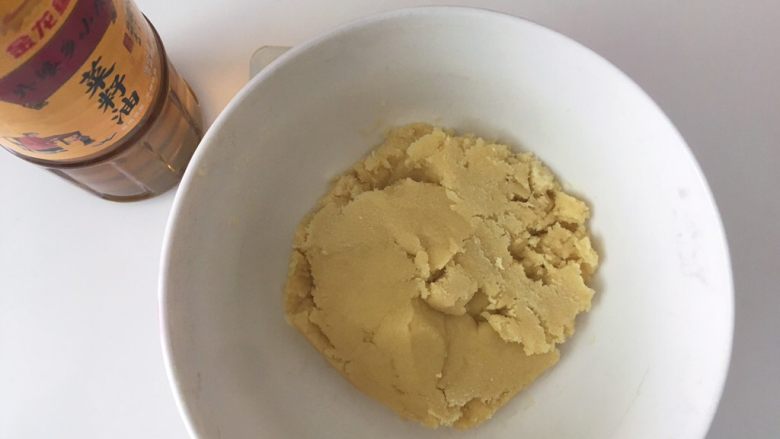 核香一口酥,水油皮揉好后,再来做油酥皮,容器内加入普通面粉跟金龙鱼菜籽油,用刮刀翻拌均匀