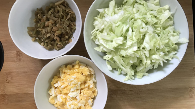 鸡蛋榨菜炒米粉,把配菜中的鸡蛋炒好,甘蓝切碎,榨菜切成小粒。