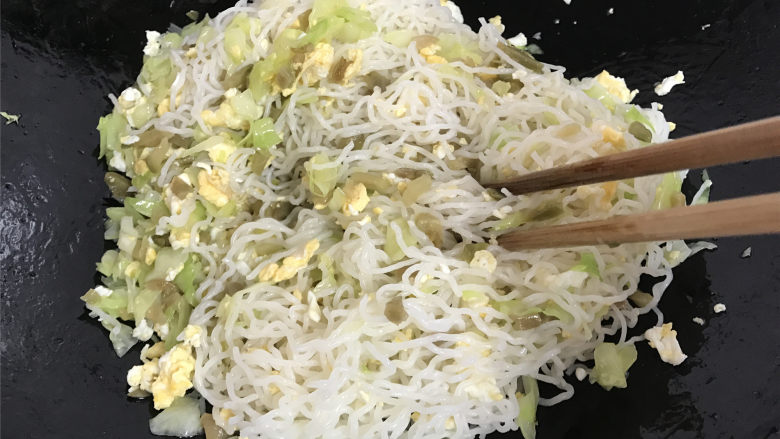 鸡蛋榨菜炒米粉,最后把泡好的米粉放入锅中,用筷子把米粉和配菜一起快速翻拌均匀。