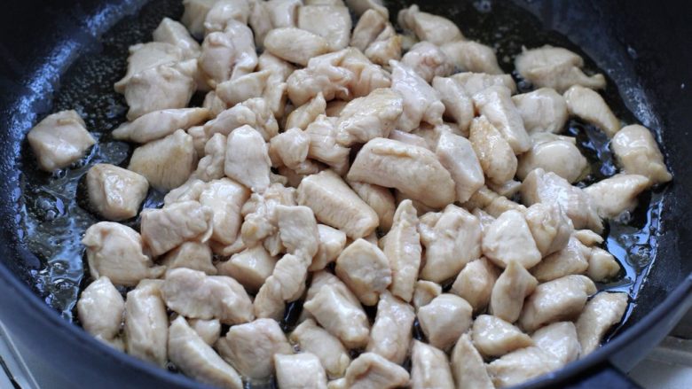 豆豉炒鸡丁,锅中倒适量食用油烧热,放入腌制好的鸡丁滑炒至变色断生状态,盛出