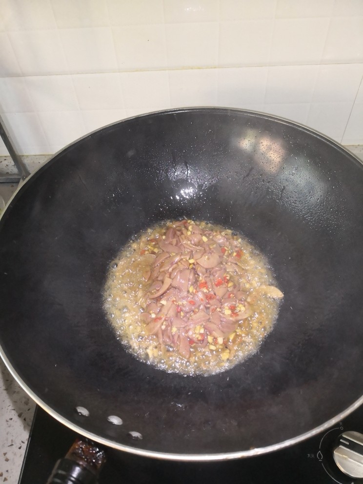 黯然销魂腰,油温烧至七八成热的时候,倒入腌制好的猪腰,并不断翻炒。