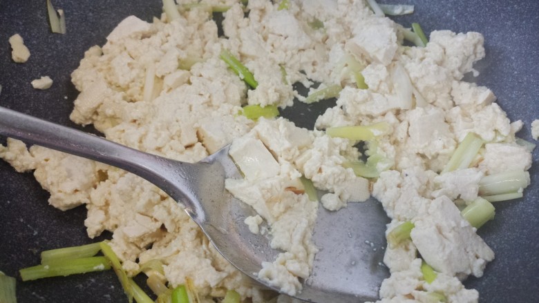 葱炒豆腐,然后把豆腐块炒碎。