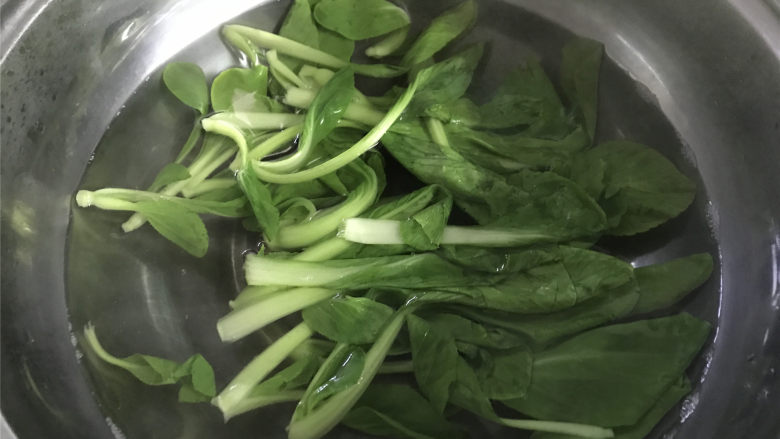 梭子蟹泡饭粥,小青菜择去老叶,洗净后放锅中焯下水。