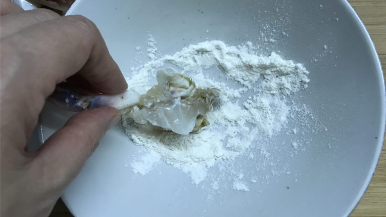 梭子蟹泡饭粥,切成小块的梭子蟹沾上面粉,沾面粉可以裹住它的膏黄,炒的时候不会流出。