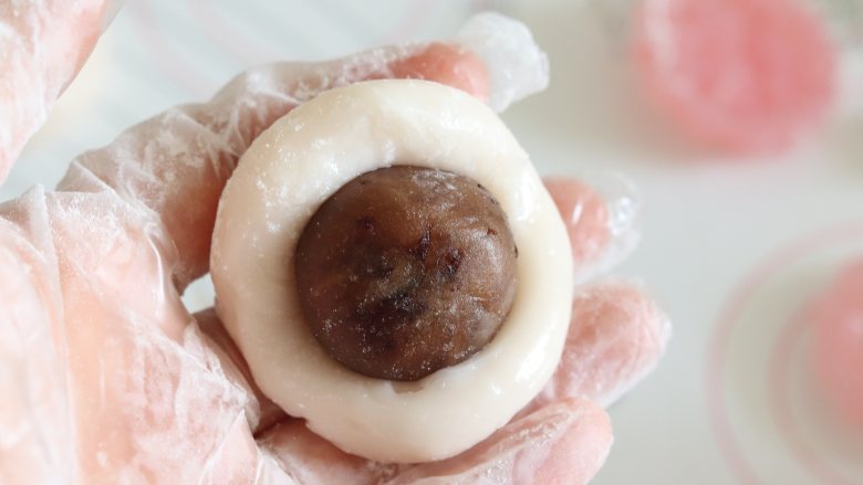 基础冰皮月饼，放3天还软糯,取一个冰皮面团，捏开，放入馅料，包好。

