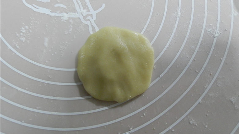 广式黑芝麻月饼,取一个饼皮,饼皮放手掌上压扁,月饼皮用旋转的手势捏薄一点(我用50克模具)