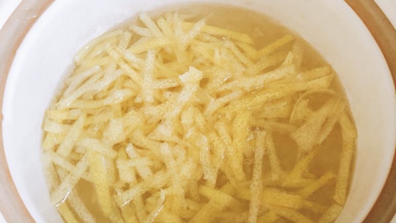 香郁柚子蜜,冰糖化开后,加入柚子皮。(柚子皮入锅之前,用清水洗一遍,洗净残留盐水,并用手抓起柚子皮捏一下,挤掉一些苦味)