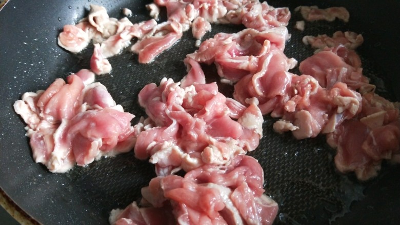 新文美食 葱爆猪肉片,先用不沾锅烧热倒入适量油,倒入肉片。