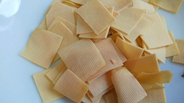 新文美食 五花肉西芹炒豆皮,<a style='color:red;display:inline-block;' href='/shicai/ 4660'>豆皮</a>切成小块。