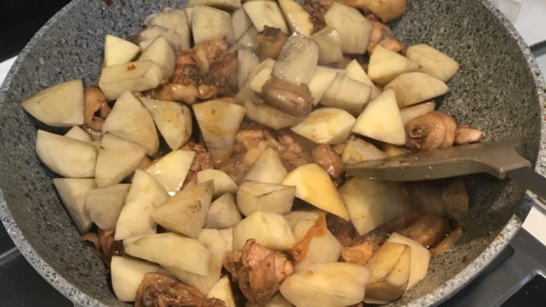 烧公鸡煲,加入土豆,翻炒均匀