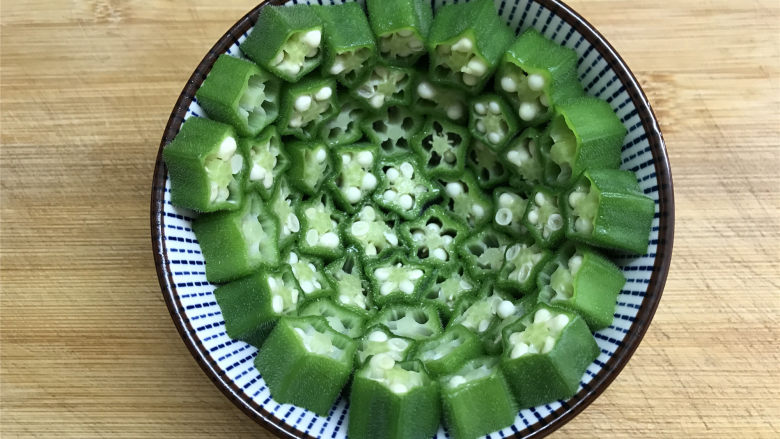 秋葵土豆泥,取一圆底小碗,把切成段的秋葵按碗的形状码入碗中。