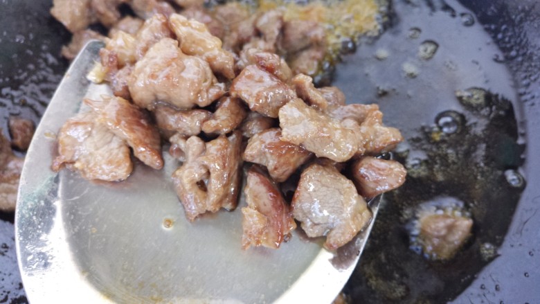 下酒菜牛肉炒酒鬼花生,然后把牛肉捞出来,控干油。