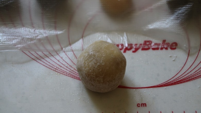 广式月饼,把包好的月饼生胚放进去滚一圈,多余的粉抖干