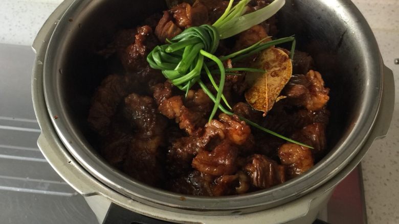 红烧牛肉,把盛牛肉的碗放在高压锅里,盖盖子,高压锅隔水蒸40–45分钟