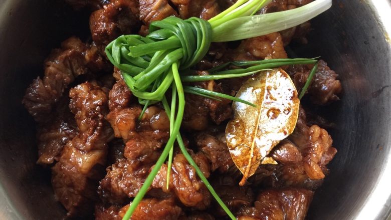红烧牛肉,把煸炒好的牛肉盛在碗里,放<a style='color:red;display:inline-block;' href='/shicai/ 3250'>葱</a>结