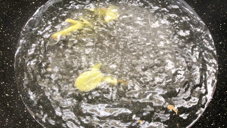 莲子猪肚汤,锅里放入一大碗水烧开,放入15g姜片