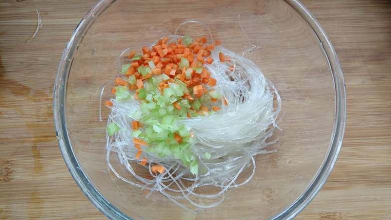 高汤粉丝蒸肉丸,泡好的粉丝沥干水,加入芹菜碎和胡萝卜碎,加入牛骨高汤拌匀。