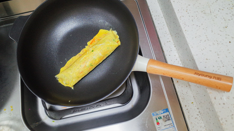 10个月以上辅食肉末蔬菜玉子烧,卷好后依然小火继续煎至鸡蛋全熟,凝固即可