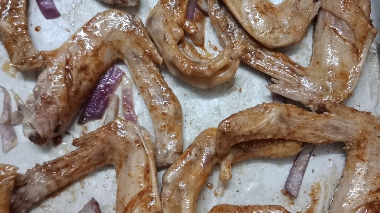 椒盐烤鸭翅鸭脚,10分钟后把烤盘拿出来,然后翻面,烤盘底会有水烤出来,可以拿厨房纸吸干水,接着刷上刷酱,也是刷的上面,再入烤箱烤10分钟