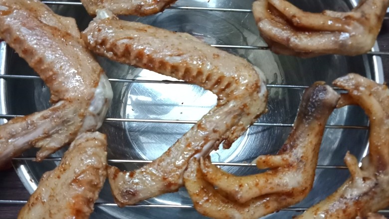 椒盐烤鸭翅鸭脚,10分钟后拿出来,然后把鸭翅鸭脚放在烤架上,入烤箱中层220度烤5分钟,这样可以把鸭翅鸭脚的水分烤干,烤箱底下记得放一张锡纸挡油哈