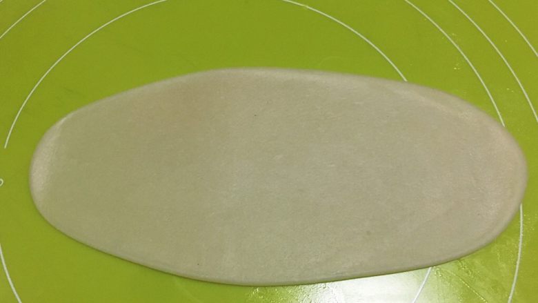 酥皮伍仁月饼,取一份包裹好的面团,用擀面杖擀成长条