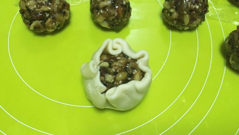 酥皮伍仁月饼,包裹上伍仁馅,收好收口,收口朝下,整理成圆形