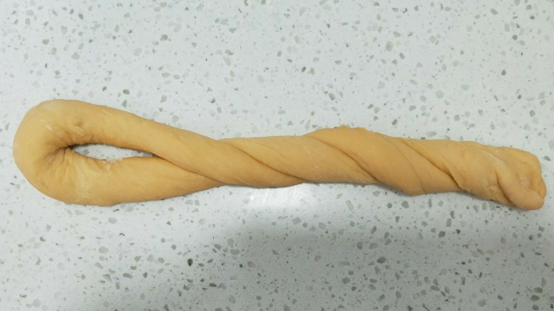 西瓜汁老式面包,两端接头处右手按住,左手将面团旋转两周