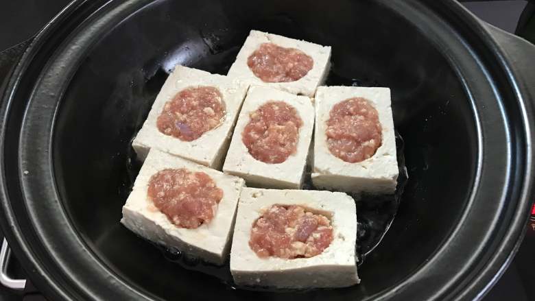 豆腐酿肉煲,砂锅中倒入油,放入豆腐煎制。