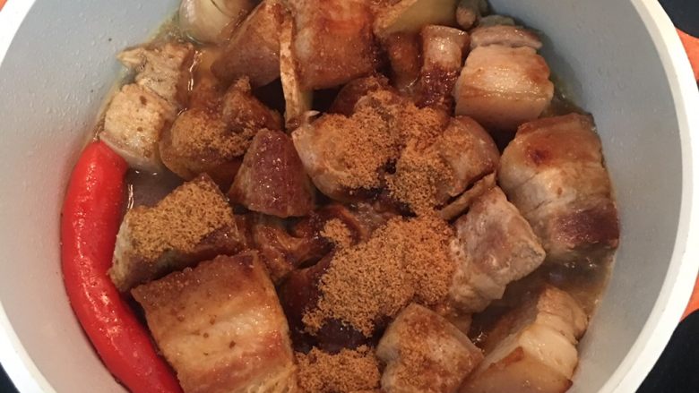 越式卤肉,20分钟后开锅盖,加入酱油、糖、鱼露并加水刚好淹过猪肉,大火煮滚后转小火,盖锅盖焖煮30分钟;