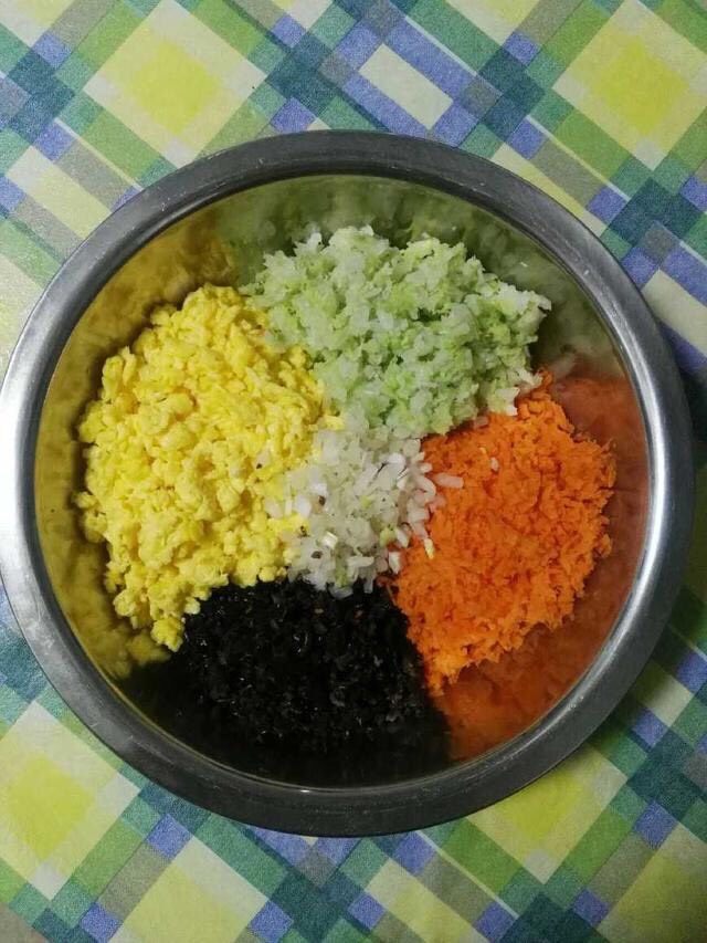 五福纯素饺,烹饪步骤:
1.面粉入盆,边少量缓慢倒水边用筷子搅拌,搅成絮状后拿掉筷子,用手揉成光滑的面团备用。醒面过程中可以准备馅料。将木耳泡发切细碎儿;将胡萝卜擦丝后切碎;将白菜切碎后放热水里焯一分钟后捞出放入凉水中过凉,而后攥出水分备用;洋葱切碎;鸡蛋搅拌后,锅中放油(多放油),油热下鸡蛋,并用筷子快速搅动,成如图状备用。