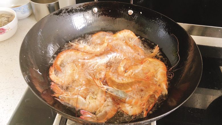 椒盐甜酒虾,油温热时,将虾全部倒入油炸。
