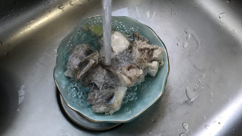 黄豆苦瓜排骨汤(懒人高压锅版),捞出煮好的排骨,用流动水冲洗一下