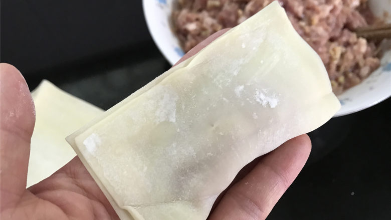 油煎馄饨,把下面的皮往上折起来。