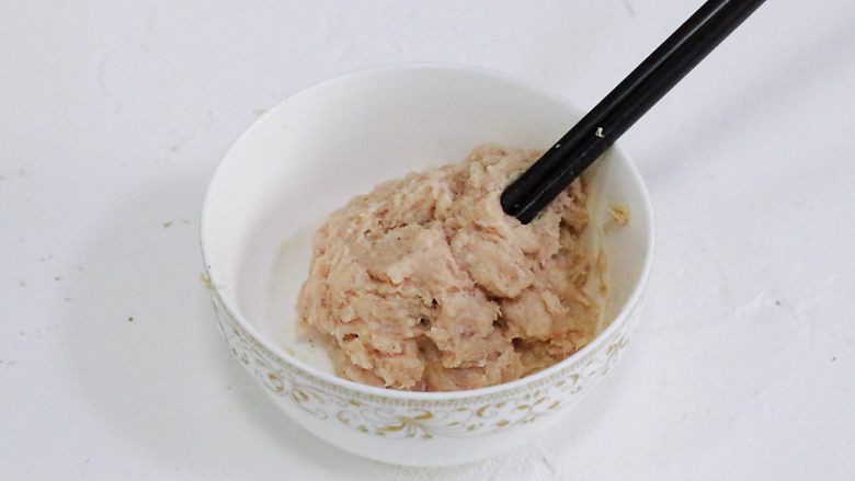 猪排米汉堡,用筷子以顺时针方向搅拌至肉沫成团,起胶。