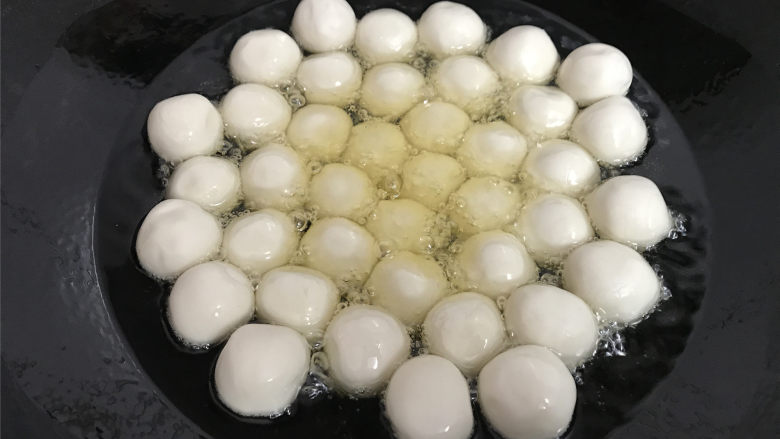 糖油粑粑,4成热时把搓好的粑粑放入锅中。