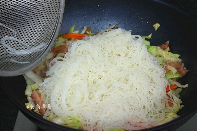午餐肉包菜炒米粉,倒入锅中,用筷子辅助炒匀,划散