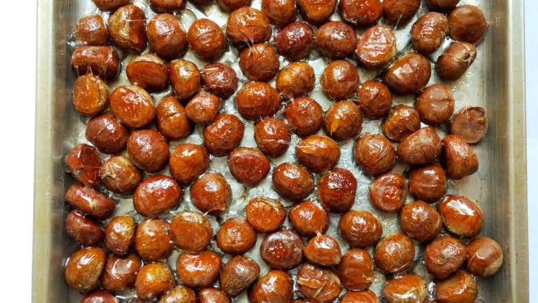糖霜栗子,20分钟后，栗子表面有些拉丝，继续刷上剩余的糖水。
