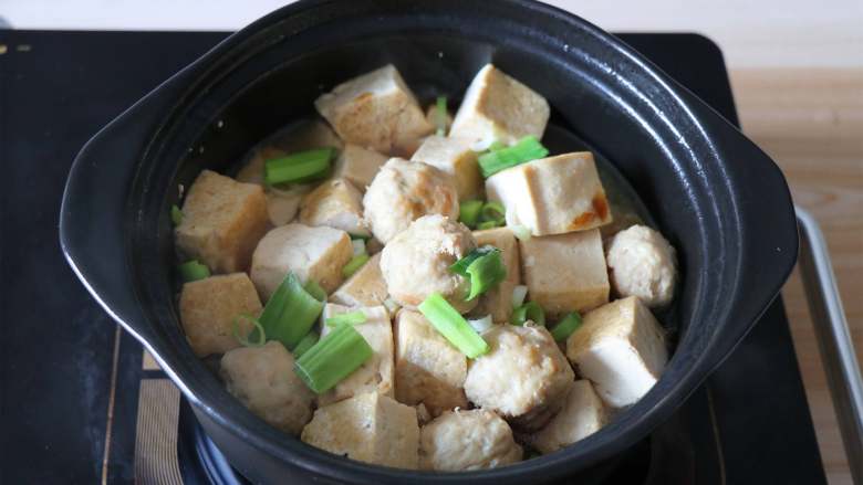 肉丸豆腐砂锅煲,继续炖煮一分钟后关火,加入适量盐调味,撒入蒜叶即可;