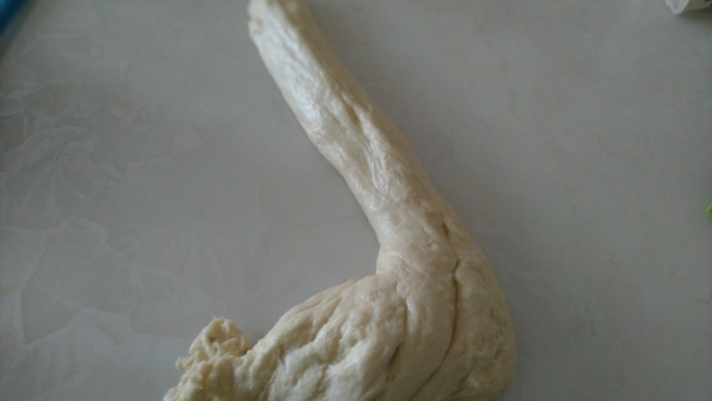 挤挤奶黄小面包,摔打10分钟,用擀面杖敲打5分钟,用搓衣法搓揉5分钟。