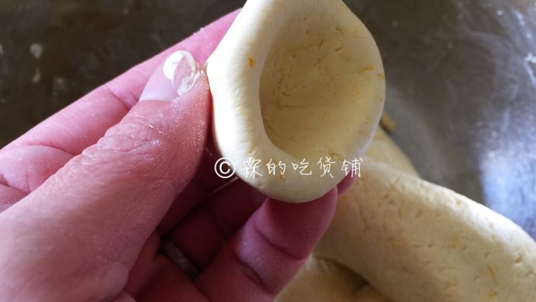 酒酿南瓜汤圆,搓成长条,摘成合适大小的剂子,揉圆,随后用右手食指按出一个坑,再和大拇指配合,一个在里一个在外,转着圈把粉团捏成个碗型