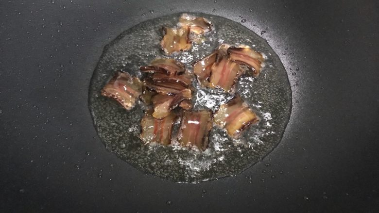 黄白菜青椒炒酱肉,待锅内油七分热时,下酱肉,翻炒至酱肉变色